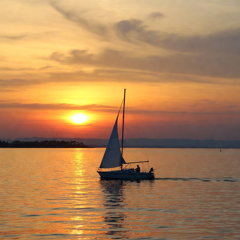 Sailboat on lake at sunset Sailboat on lake at sunset