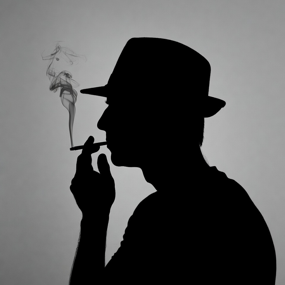 Silhouette man smoking cigarette in fedora Silhouette man smoking cigarette in fedora