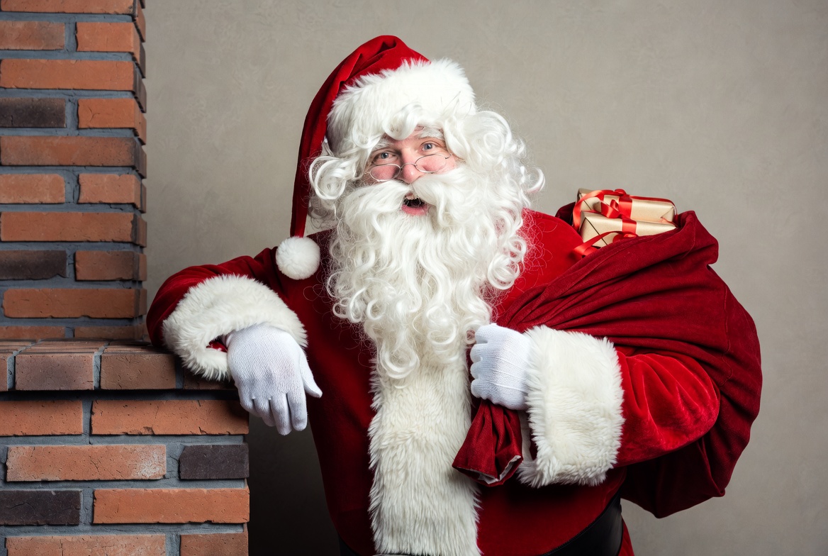 Santa Claus with sack by fireplace Santa Claus with sack by fireplace