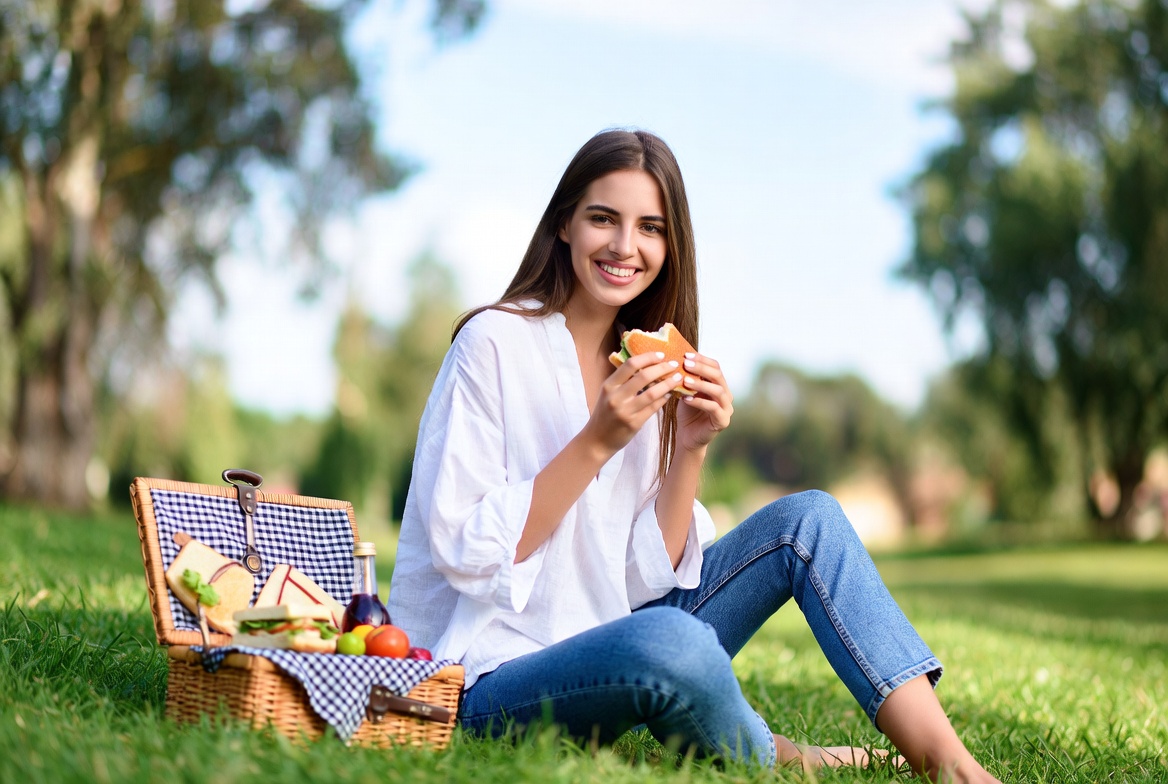 Woman eating sandwich at picnic Woman eating sandwich at picnic