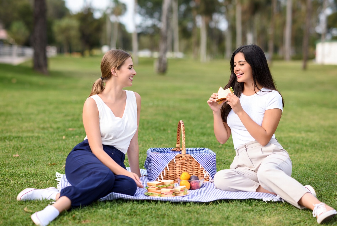 Two women enjoying picnic in park Two women enjoying picnic in park