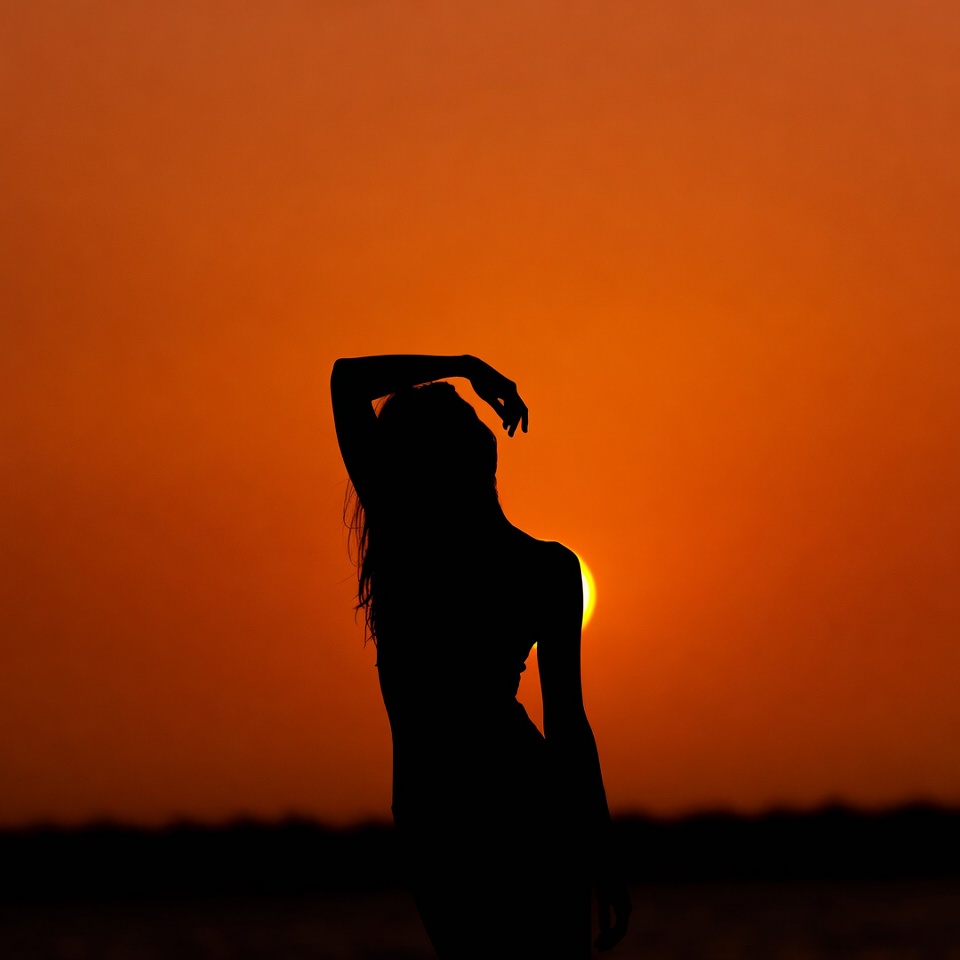 Woman silhouette against sunset Woman silhouette against sunset