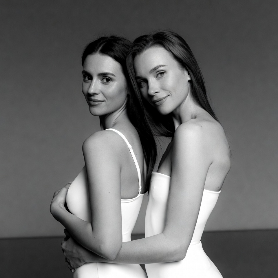 Two women embracing in white dresses Two women embracing in white dresses