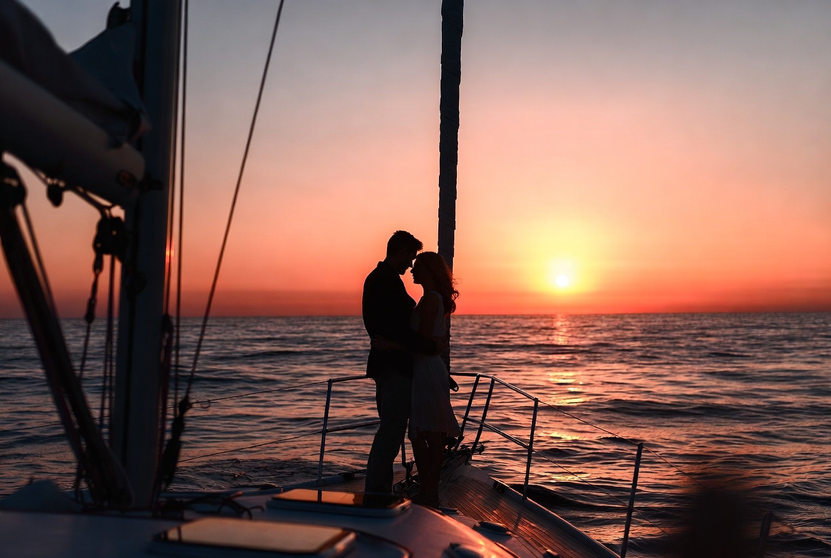 Silhouette couple kissing on yacht at sunset Silhouette couple kissing on yacht at sunset