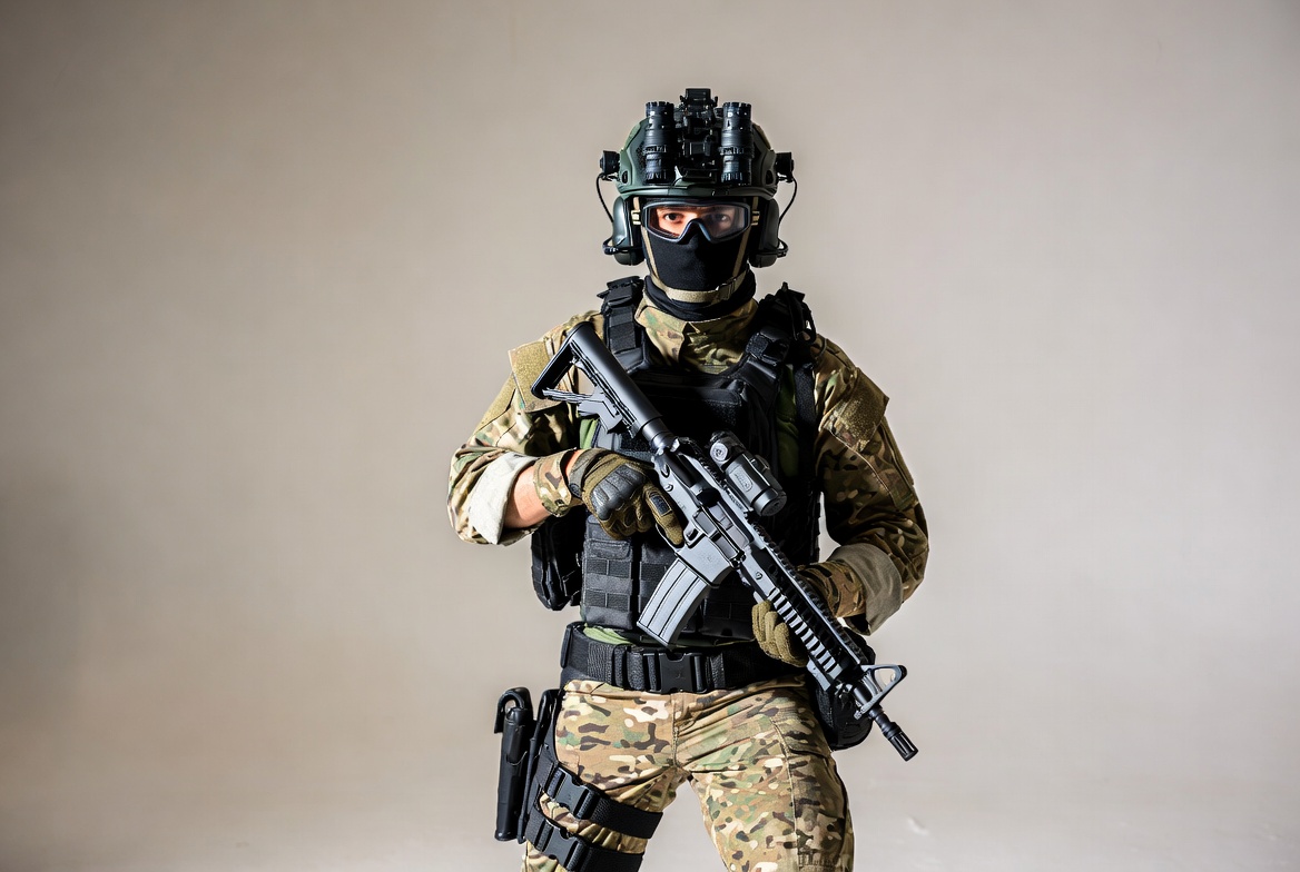 Soldier holding rifle in camouflage gear Soldier holding rifle in camouflage gear
