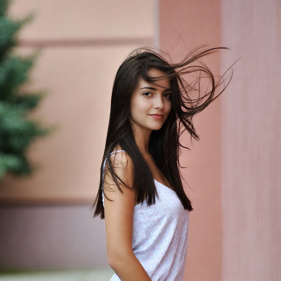 Woman with flowing hair by pink building Woman with flowing hair by pink building