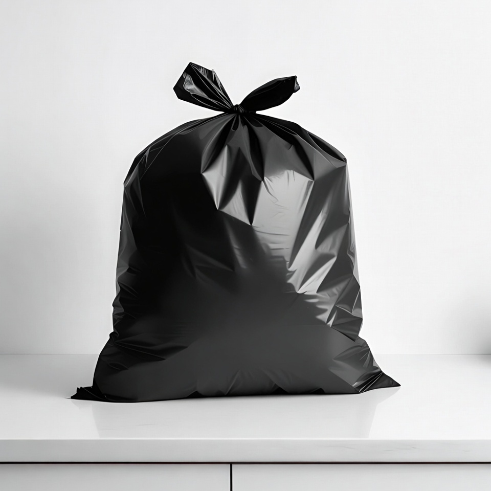 Black trash bag tied on white surface Black trash bag tied on white surface