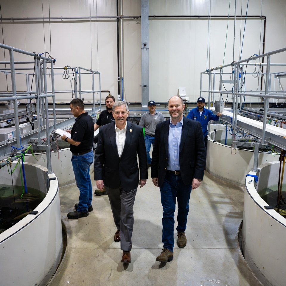 Men touring fish farm facility Men touring fish farm facility