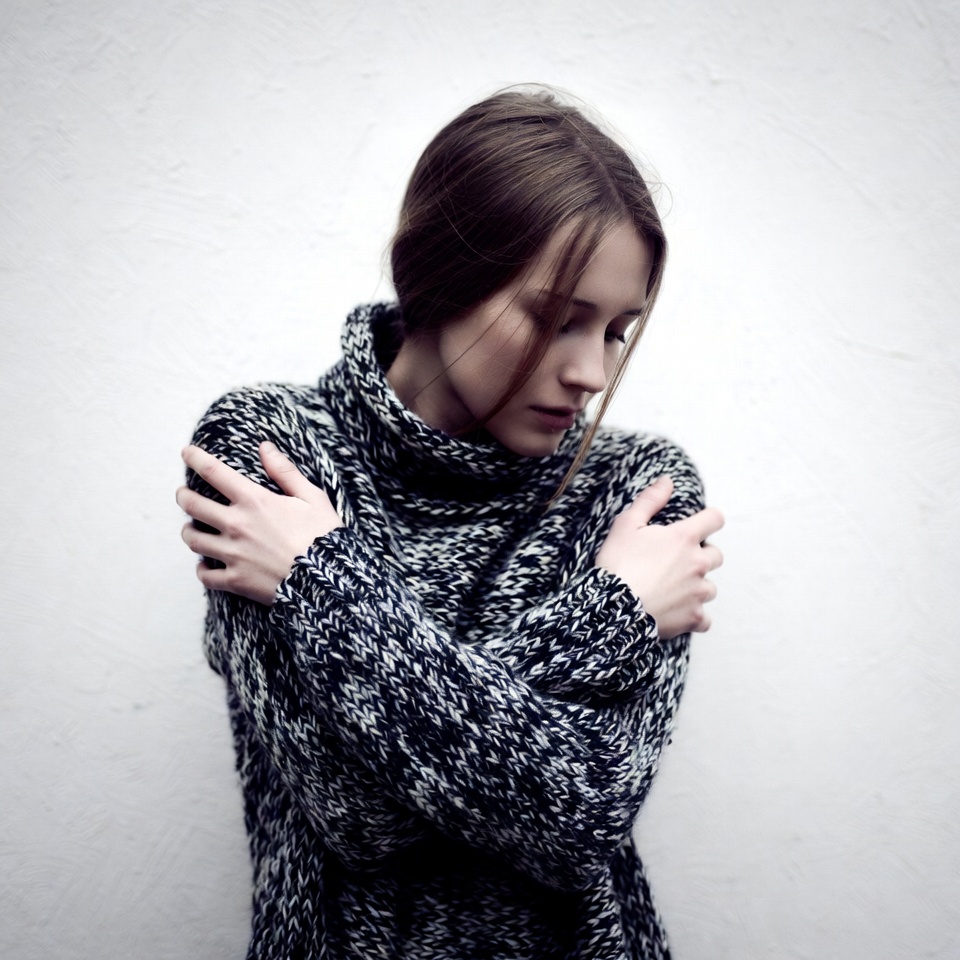 Woman hugging herself in turtleneck sweater Woman hugging herself in turtleneck sweater