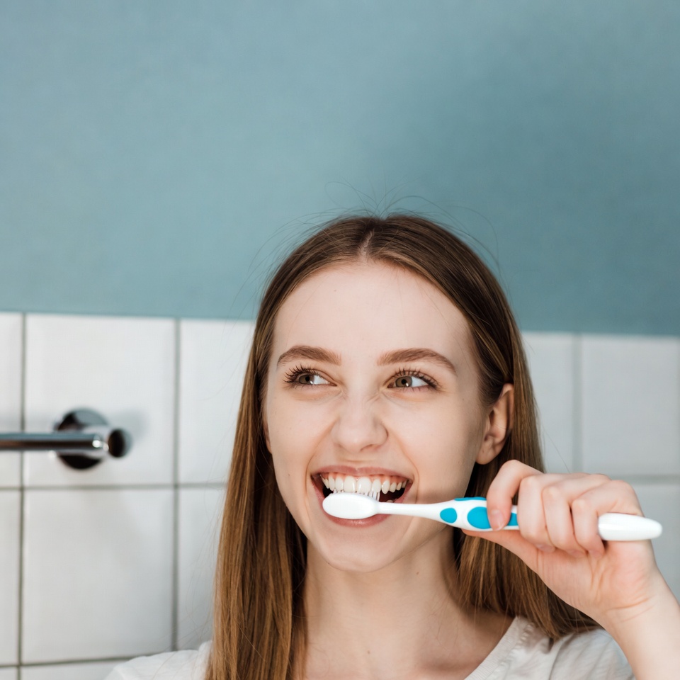 Woman brushing teeth in bathroom Woman brushing teeth in bathroom