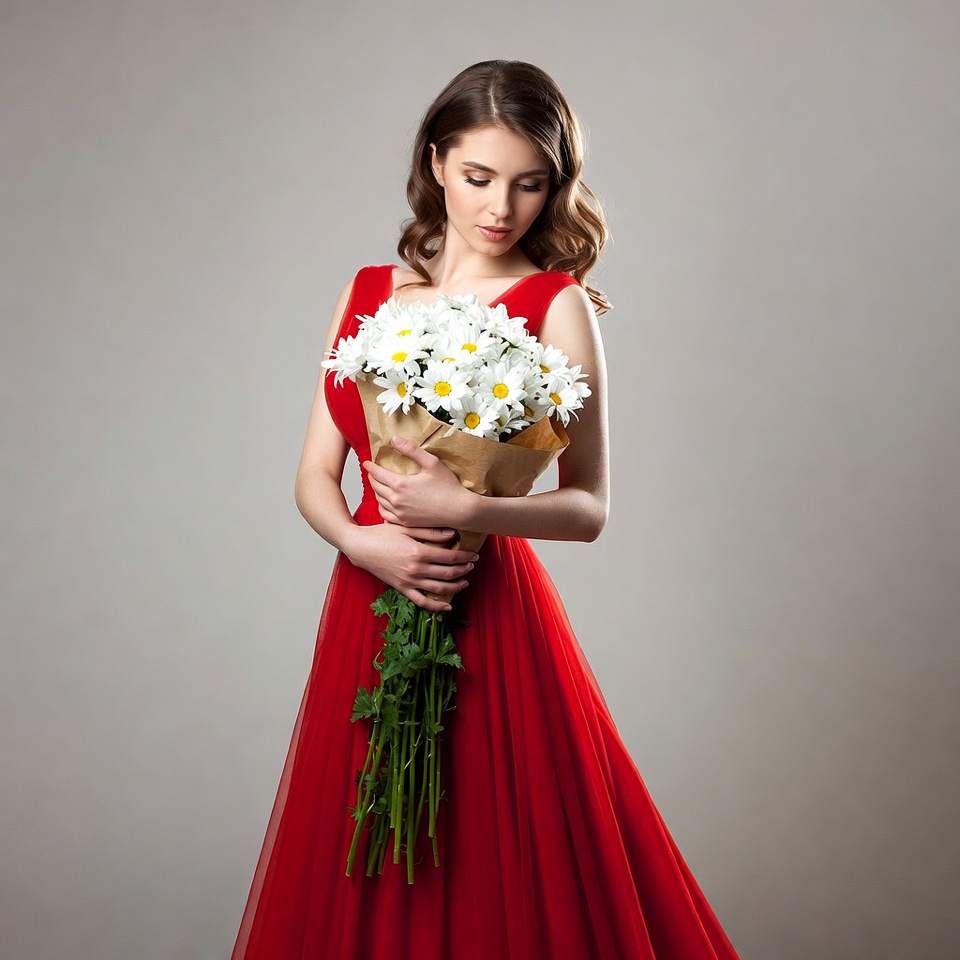 Woman holding daisies in red dress Woman holding daisies in red dress