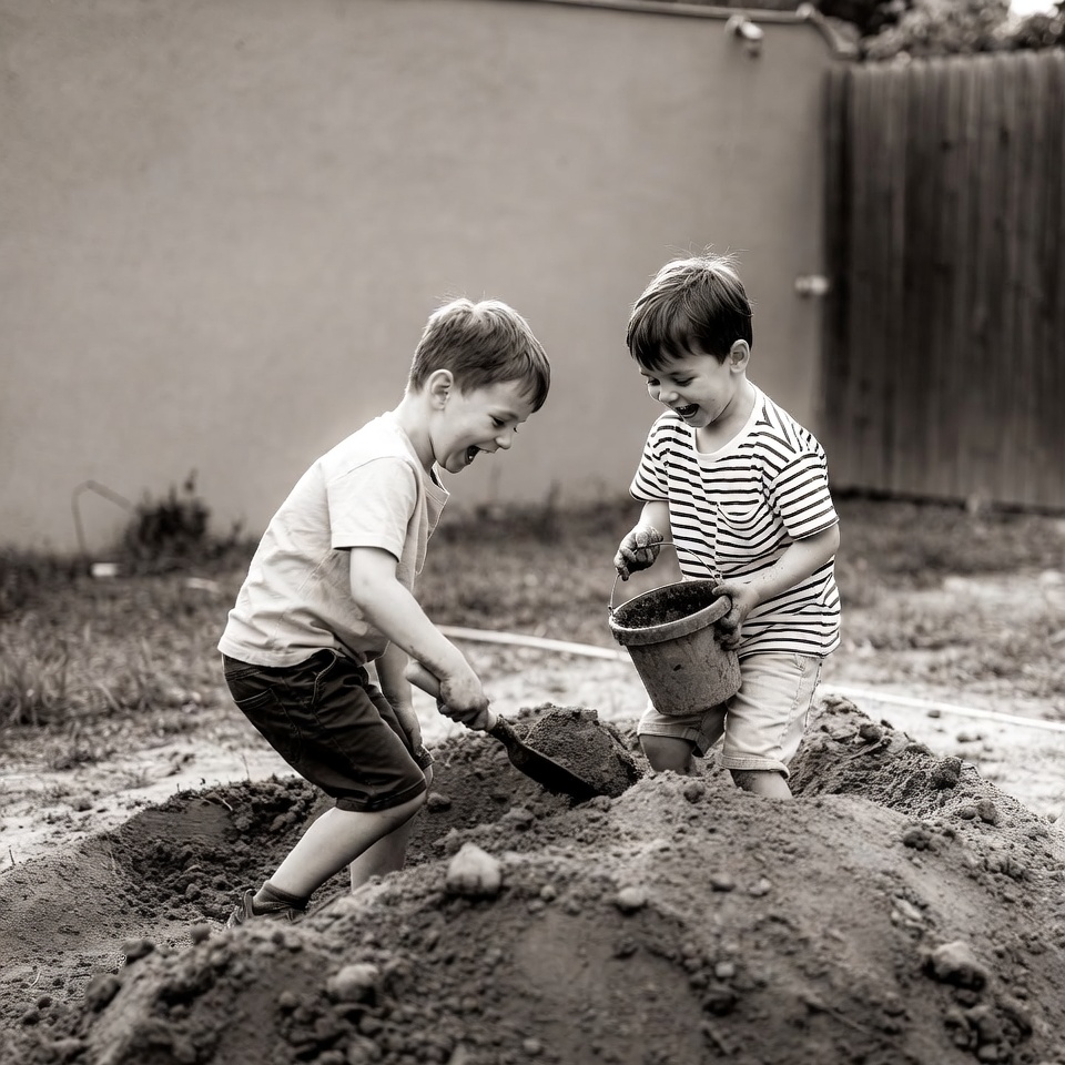 Two boys playing in sand pile Two boys playing in sand pile
