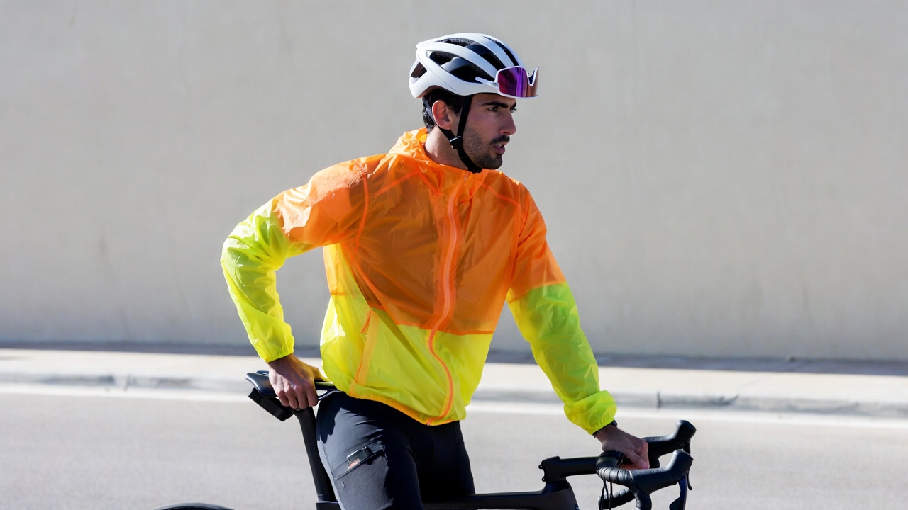 Man cycling in orange rain jacket Man cycling in orange rain jacket