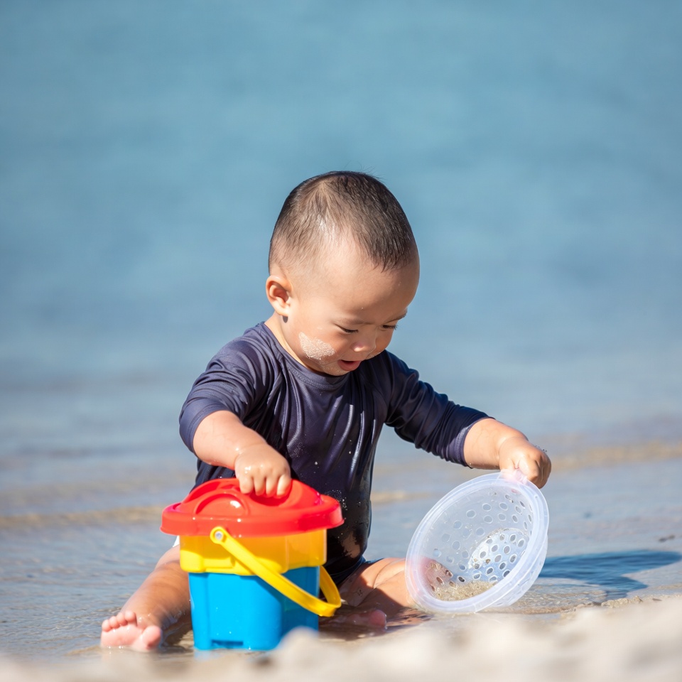 Asian baby playing with beach toys Asian baby playing with beach toys