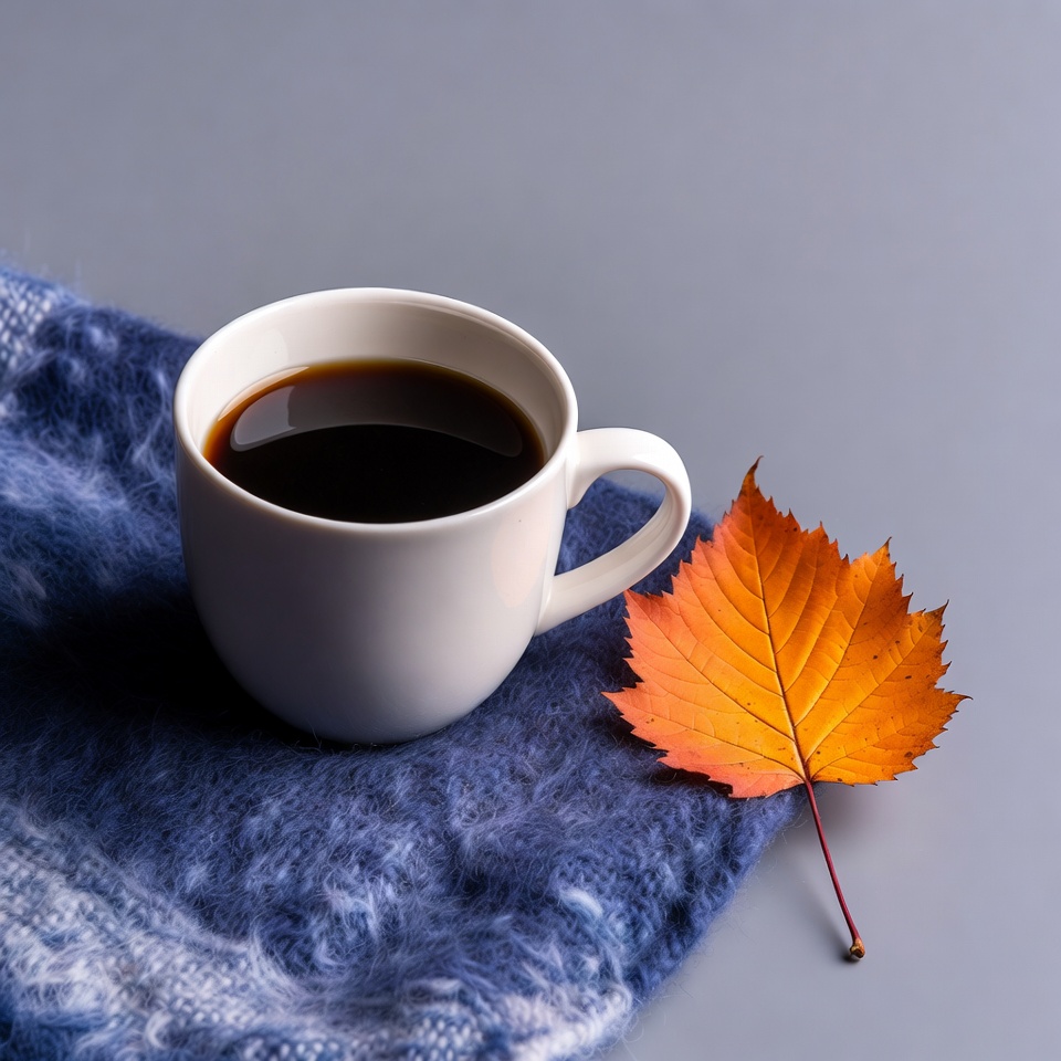 Coffee Cup with Autumn Leaf on Blanket Coffee Cup with Autumn Leaf on Blanket