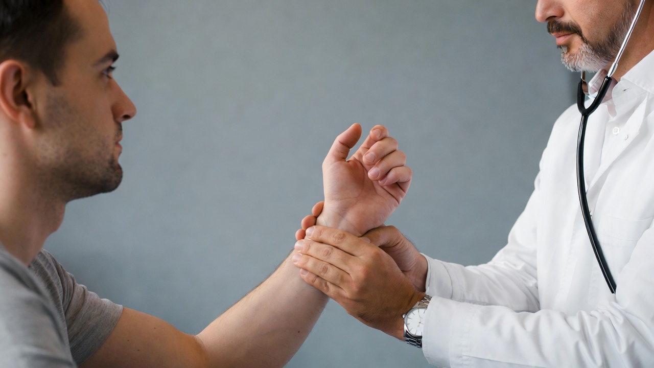 Doctor examining man's wrist Doctor examining man's wrist