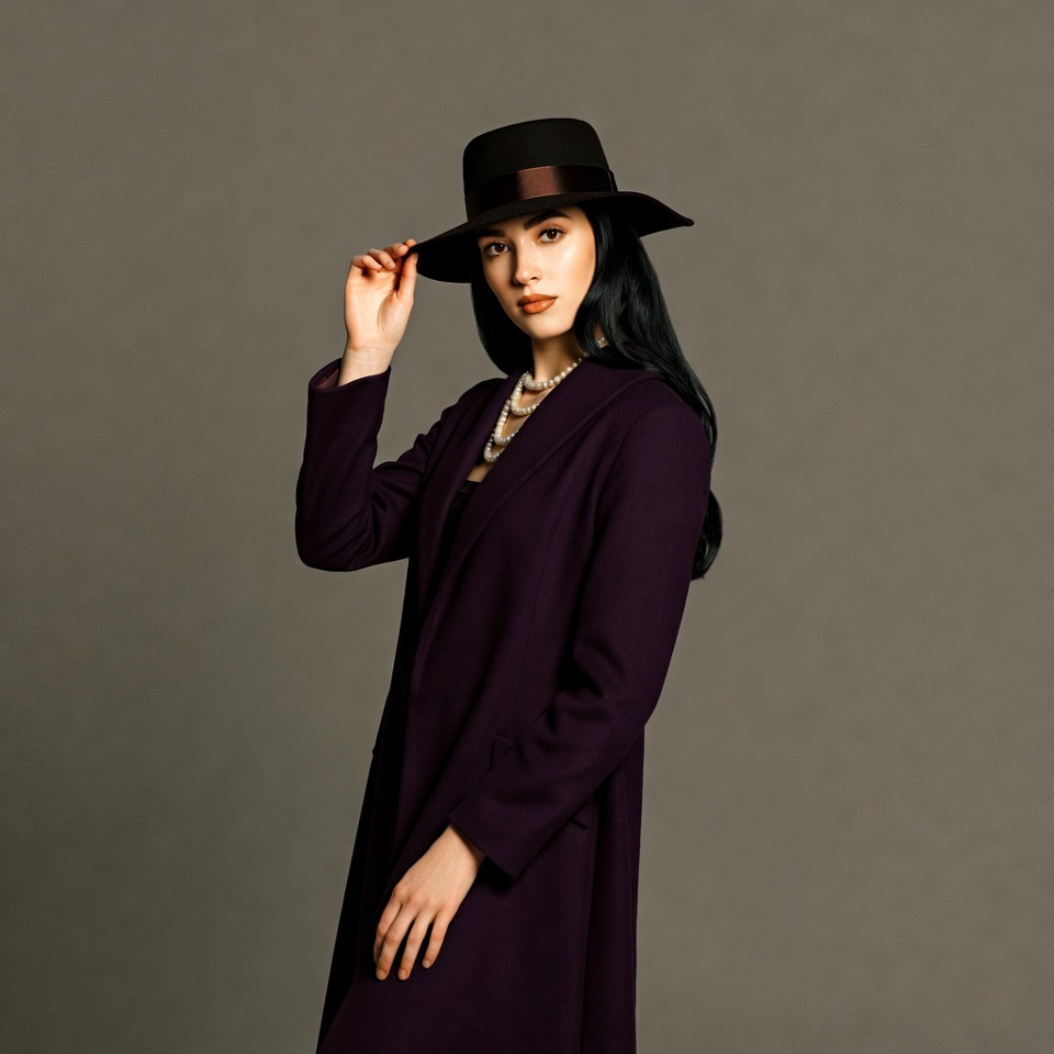 Asian woman tipping black fedora hat Asian woman tipping black fedora hat