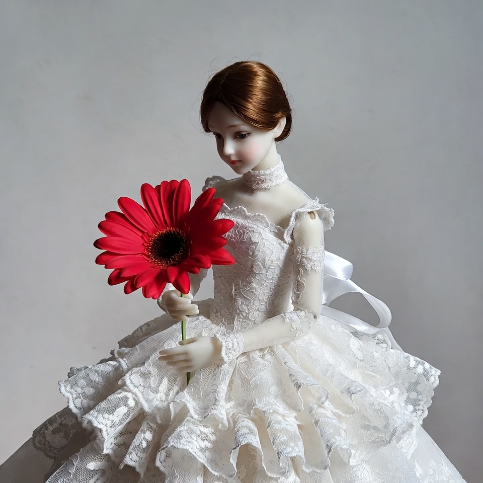 Doll holding red daisy Doll holding red daisy