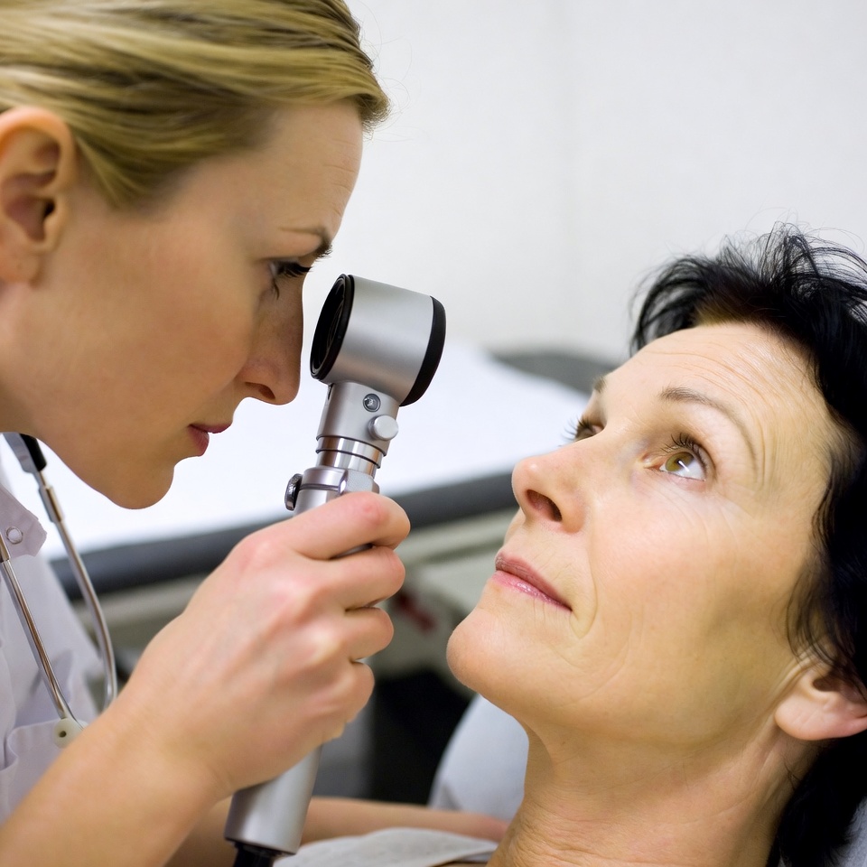 Blonde nurse examining patient's eyes Blonde nurse examining patient's eyes