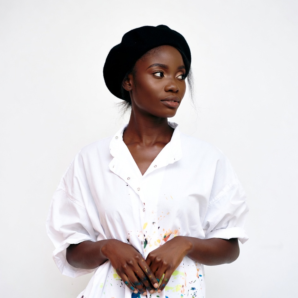 African-American woman in beret with paint-splattered shirt African-American woman in beret with paint-splattered shirt