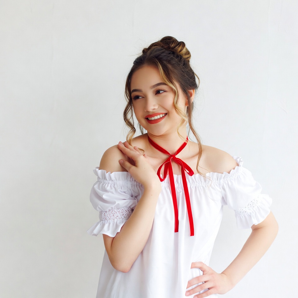 Young woman in white off-shoulder top with red bow Young woman in white off-shoulder top with red bow