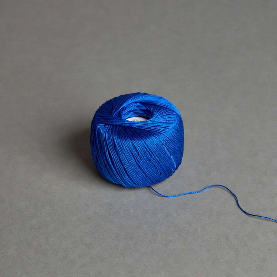 Blue thread spool on gray background Blue thread spool on gray background