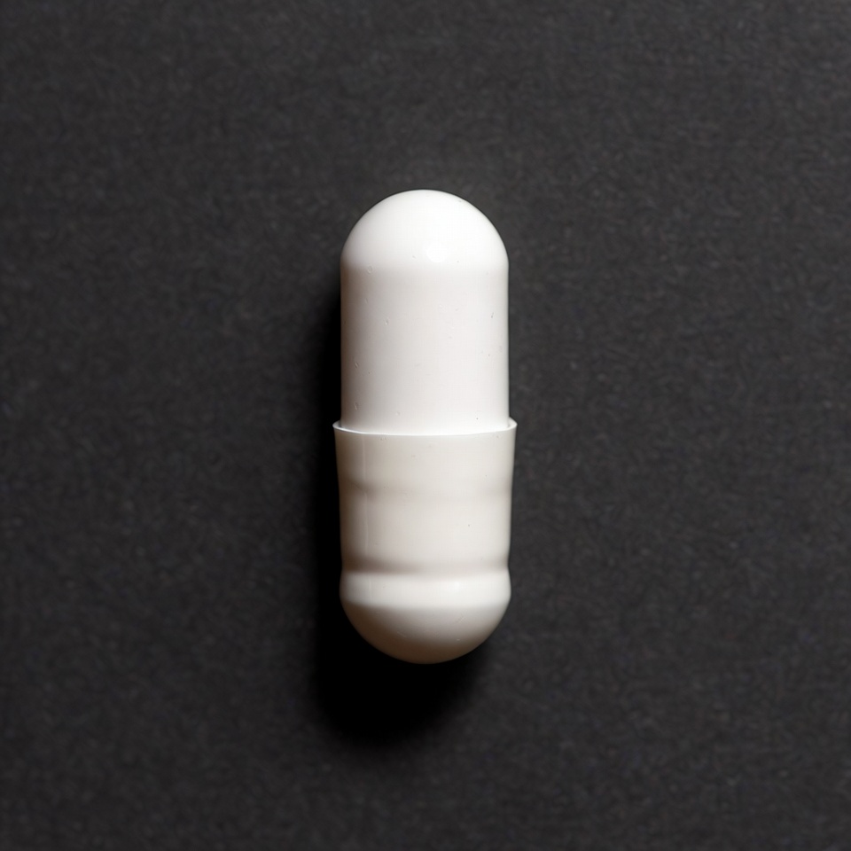 White capsule pill on black background White capsule pill on black background
