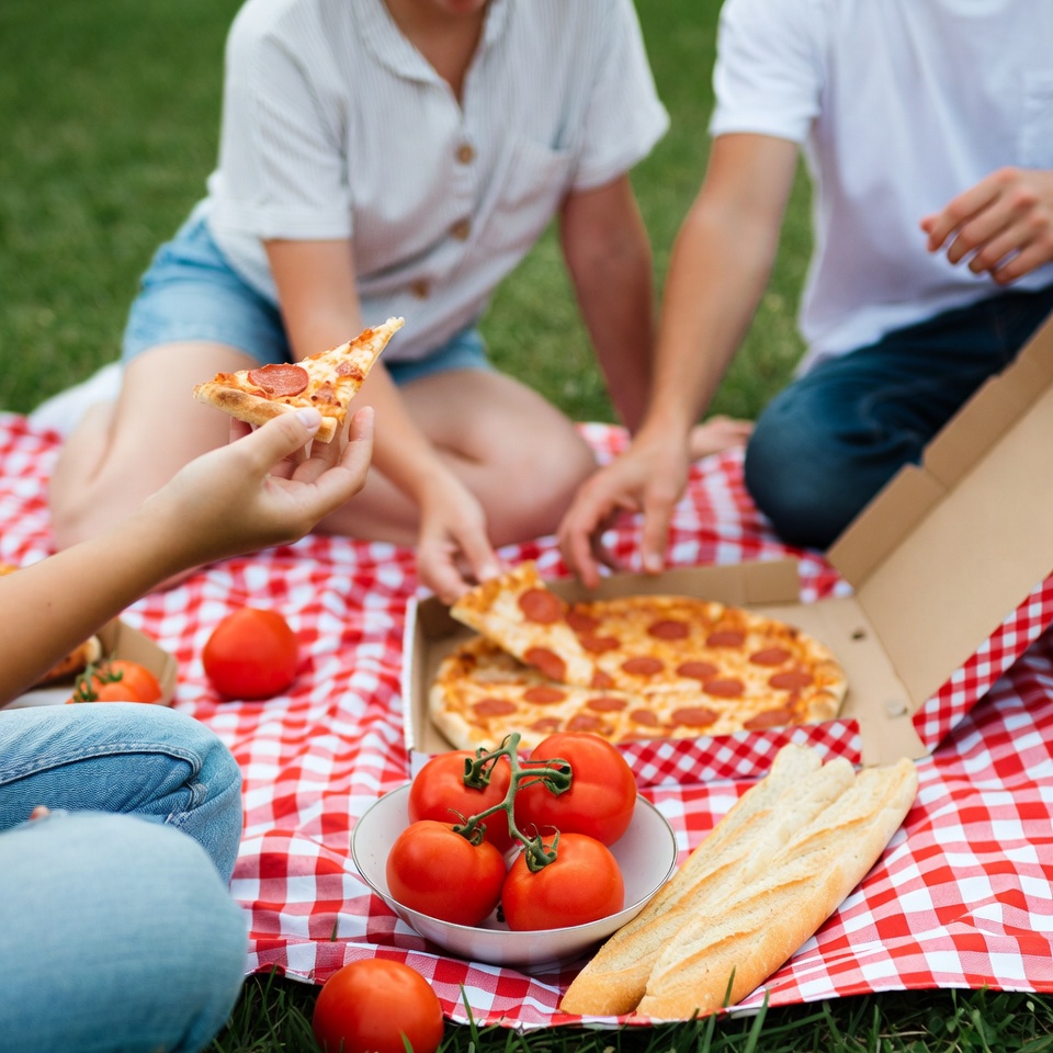 Couple eating pizza picnic outdoors Couple eating pizza picnic outdoors