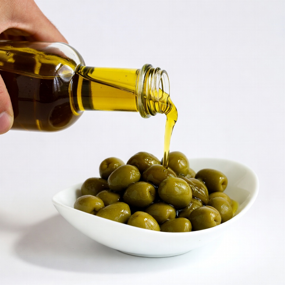 Hand pouring olive oil on olives Hand pouring olive oil on olives