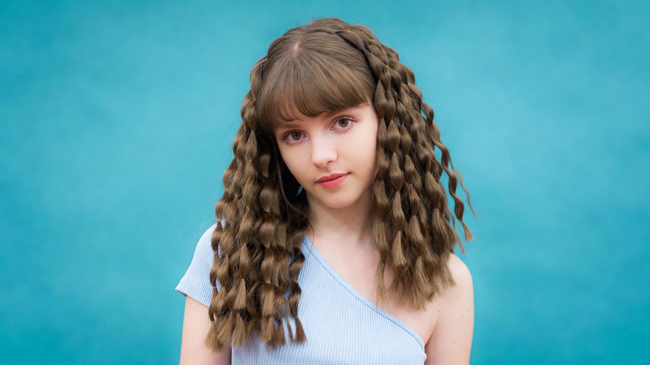 Girl with curly bangs on blue background Girl with curly bangs on blue background