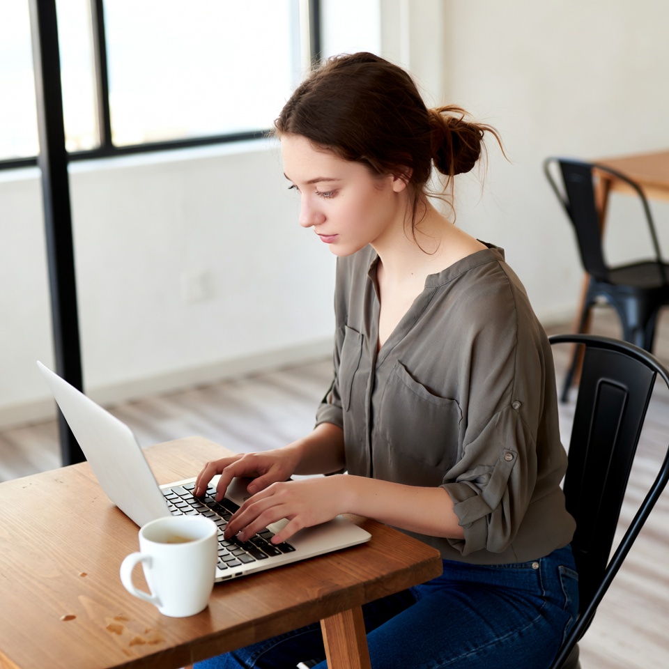 Woman working on laptop with coffee Woman working on laptop with coffee