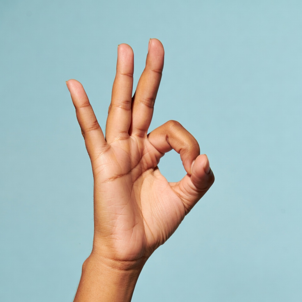 OK hand gesture on blue background OK hand gesture on blue background