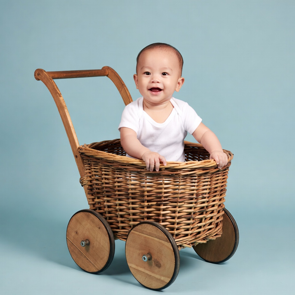 Asian baby smiling in wicker stroller Asian baby smiling in wicker stroller