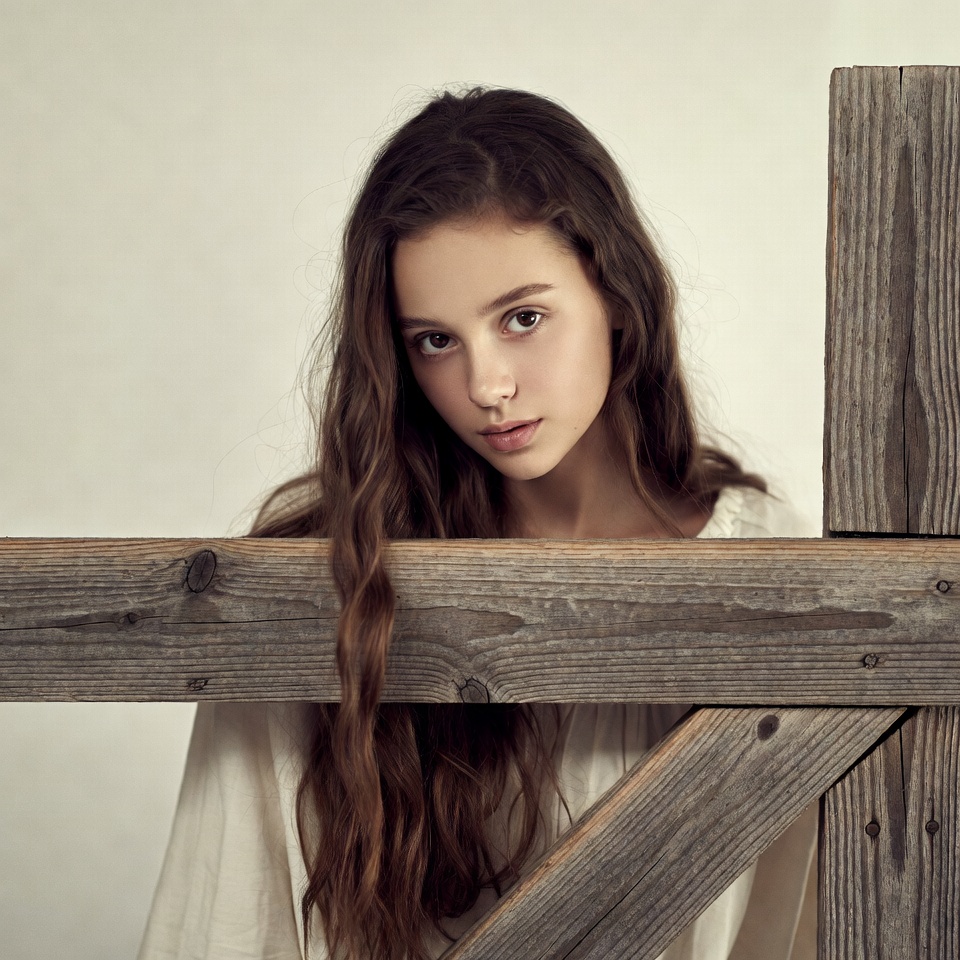 Girl peeking over wooden fence Girl peeking over wooden fence