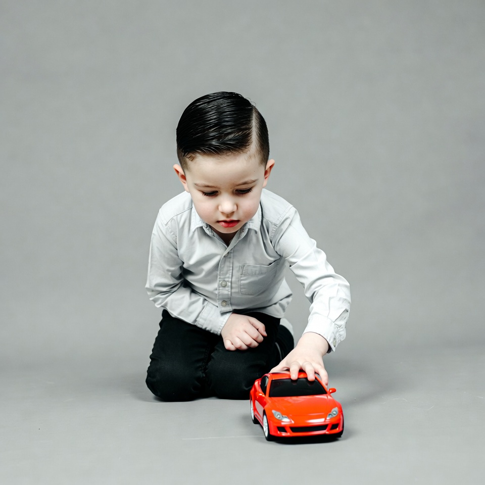 Boy playing with red toy car Boy playing with red toy car