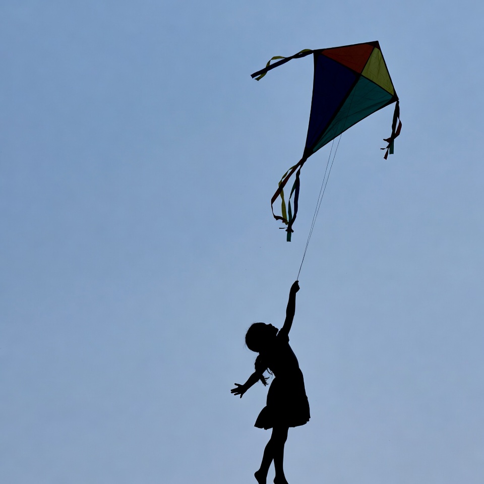 Girl flying colorful kite silhouette Girl flying colorful kite silhouette