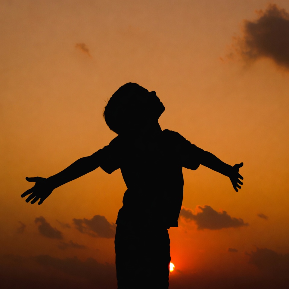 Boy silhouette arms outstretched sunset Boy silhouette arms outstretched sunset