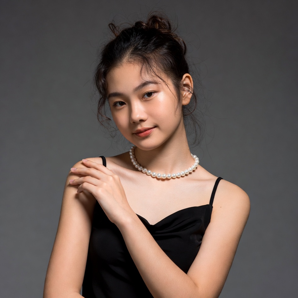 Asian woman in black dress with pearl necklace Asian woman in black dress with pearl necklace