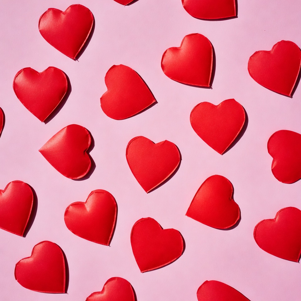 Red hearts scattered on pink background Red hearts scattered on pink background