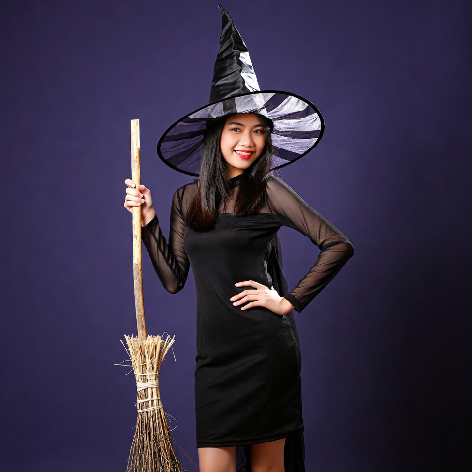 Asian woman in witch costume with broom Asian woman in witch costume with broom
