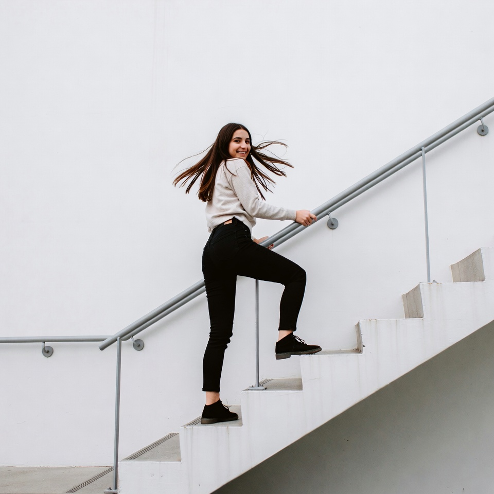 Woman climbing white stairs Woman climbing white stairs