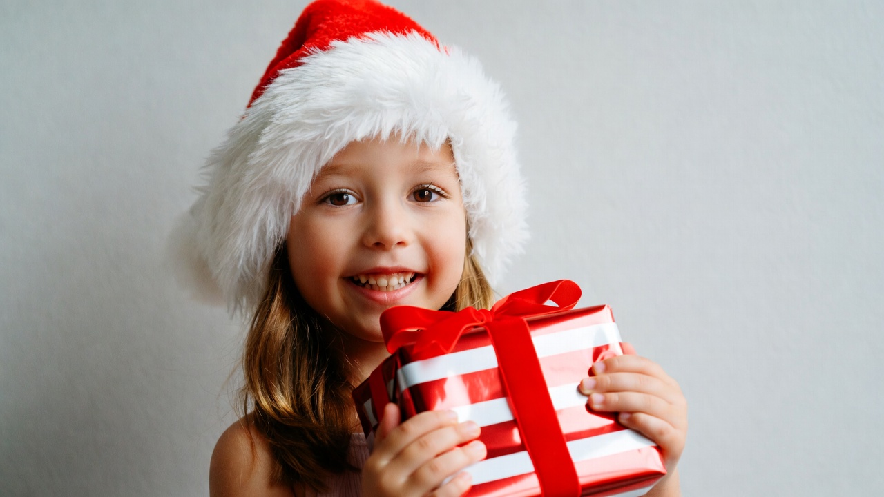 Girl holding red Christmas gift Girl holding red Christmas gift