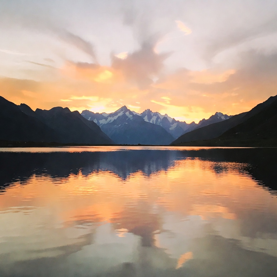 Sunset over snowy mountains and lake Sunset over snowy mountains and lake