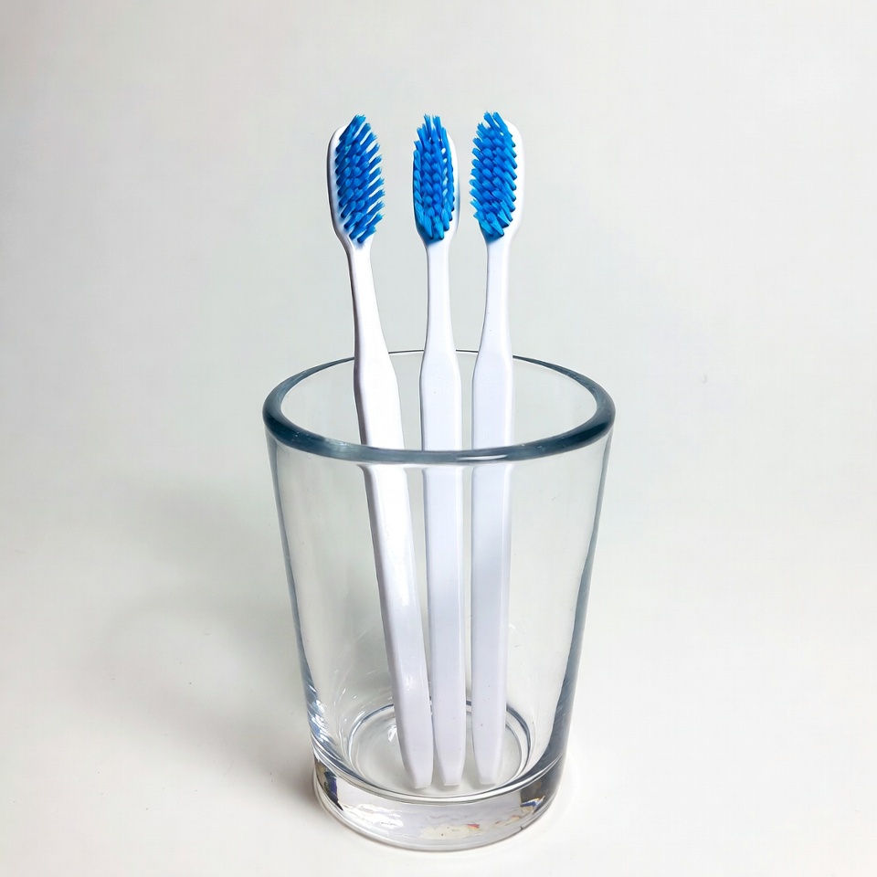 Three Blue Toothbrushes in Glass Three Blue Toothbrushes in Glass