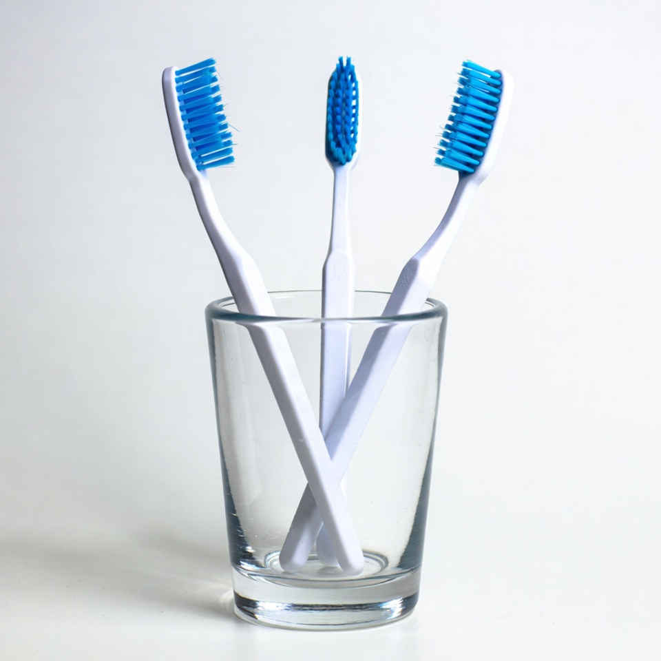 Three Blue Toothbrushes in Glass Three Blue Toothbrushes in Glass