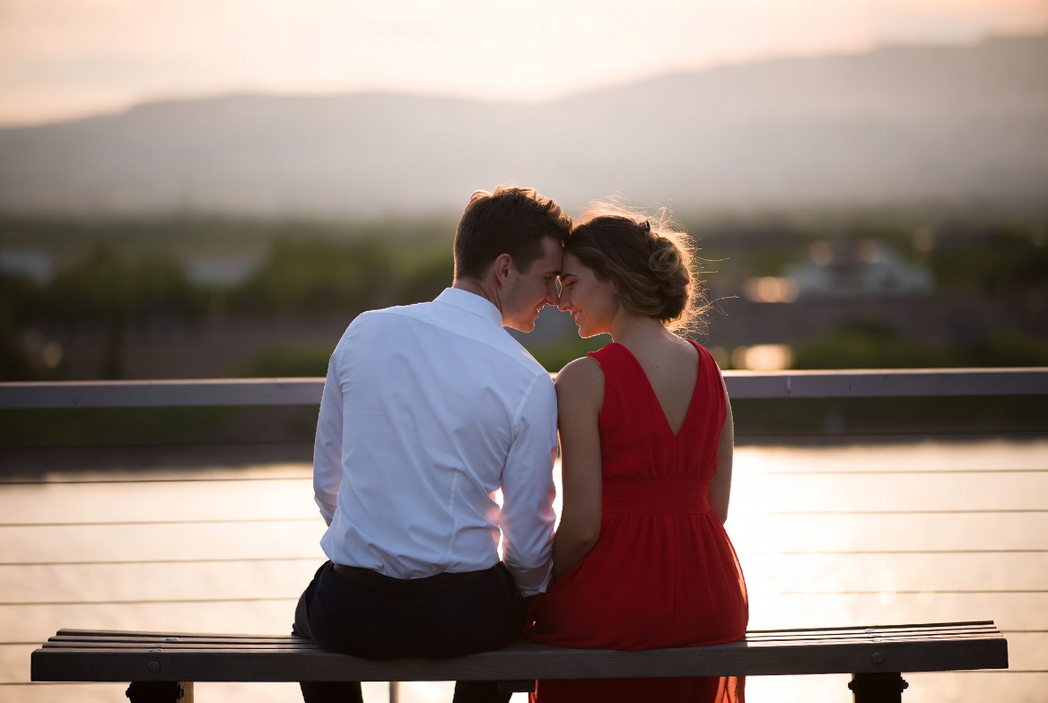 Couple embracing on bench at sunset Couple embracing on bench at sunset