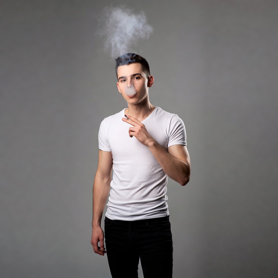 Young man blowing vape smoke Young man blowing vape smoke
