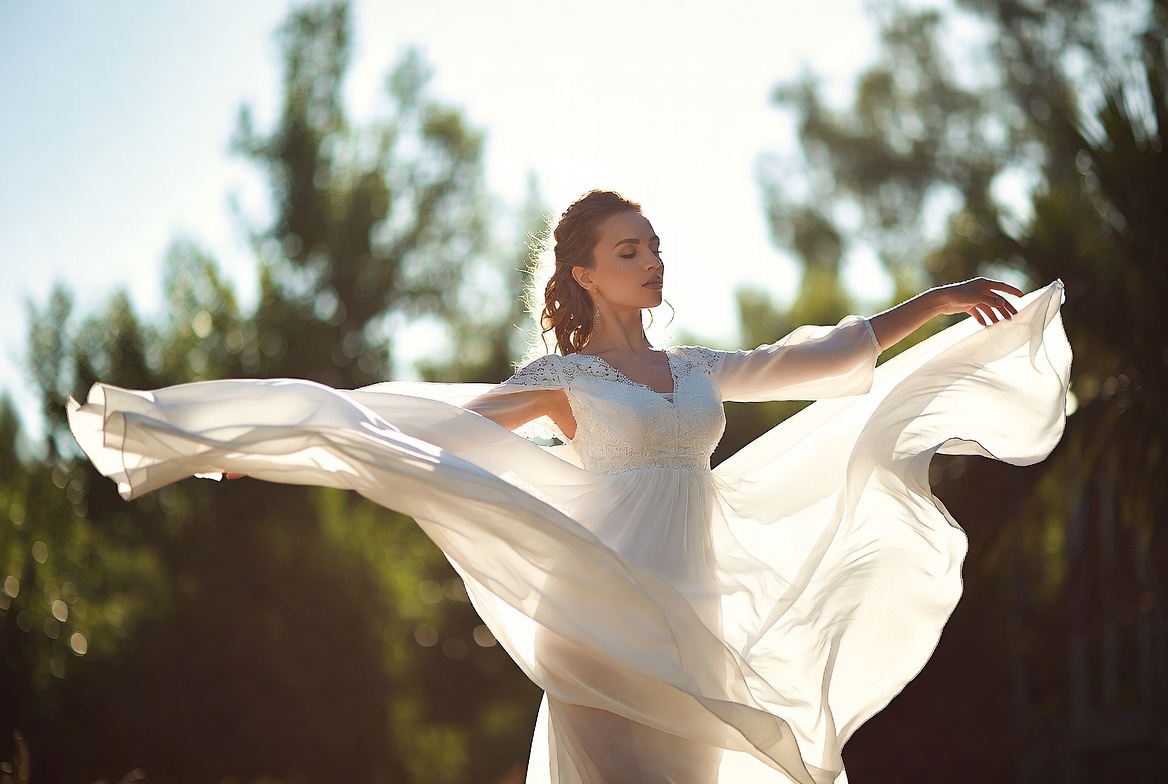 Woman twirling in white dress outdoors Woman twirling in white dress outdoors