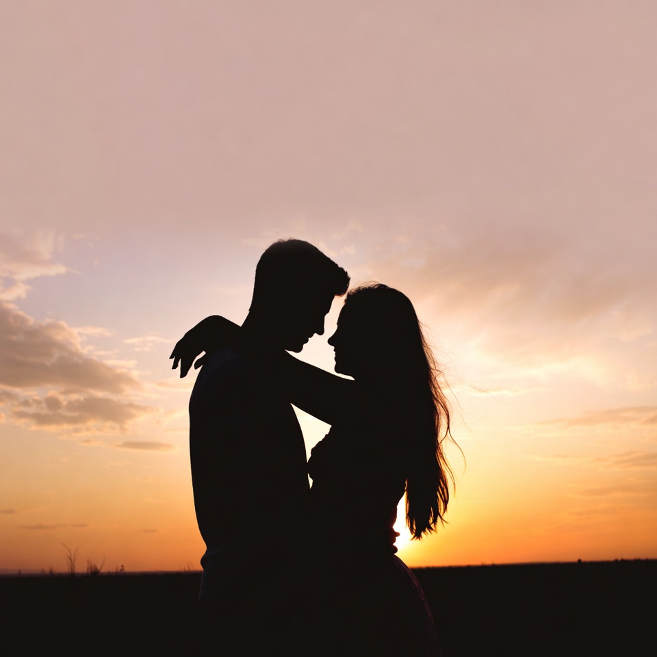 Silhouette couple embracing at sunset Silhouette couple embracing at sunset
