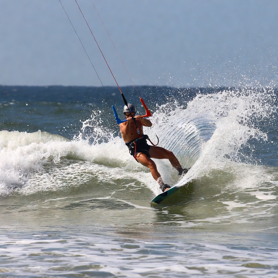 Man kitesurfing on ocean waves Man kitesurfing on ocean waves